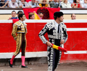 Iván García con banderillas revestidas con la enseña nacional, al fondo Cayetano