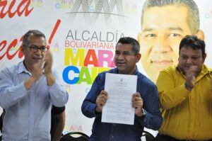 El alcalde, mostrando la firma de la prohibición.