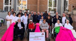 Residentes y organizadores de la becerrada posan detrás del talón entregado, con Sergio Sánchez en el centro de la imagen.