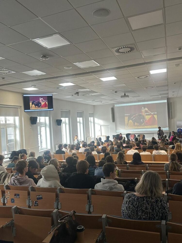 Auditorio lleno de estudiantes durante una presentación en pantalla