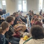 Grupo de estudiantes sentados en un aula conversando y compartiendo ideas.