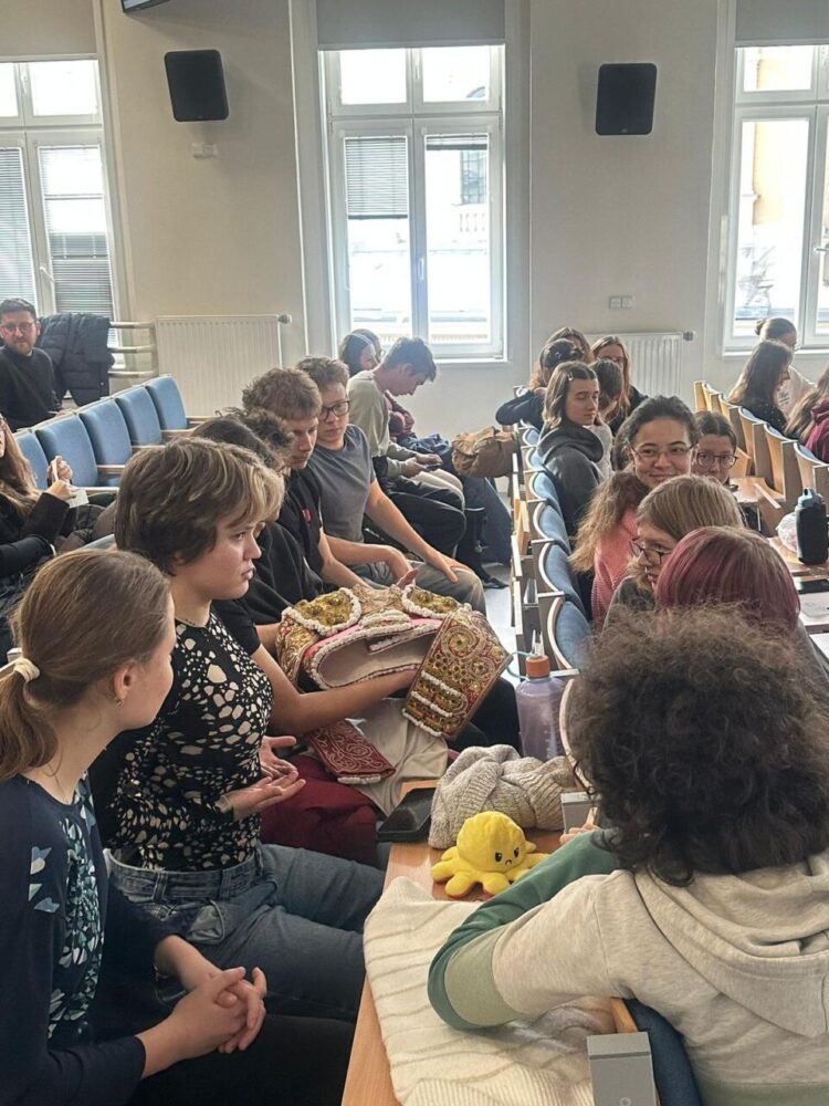 Grupo de estudiantes sentados en un aula conversando y compartiendo ideas.