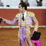 Torero sosteniendo un trofeo en una plaza de toros