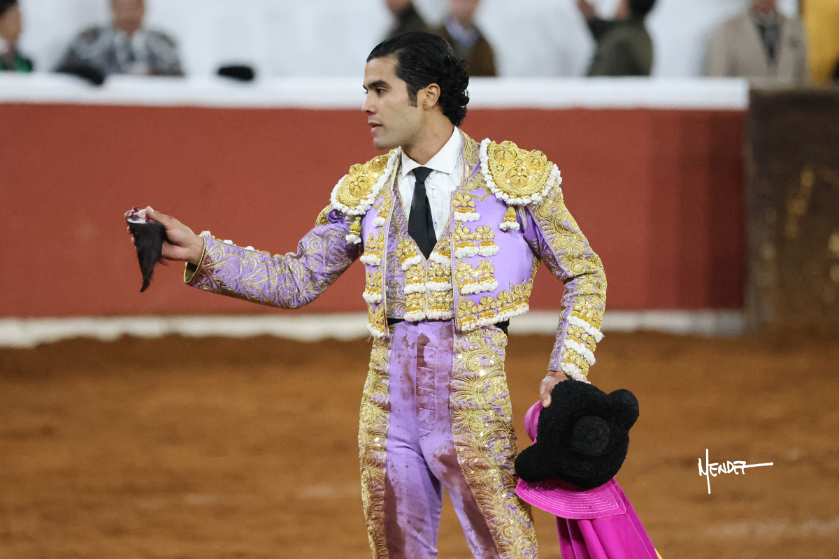 Torero sosteniendo un trofeo en una plaza de toros